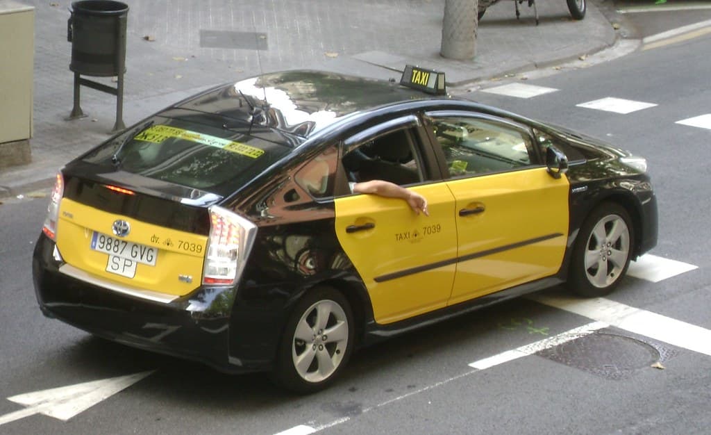 Taxi Toyota Prius Plus en Barcelona, negro con puertas amarillas